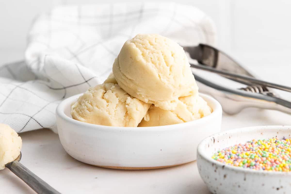 Edible sugar cookie dough scooped into white bowl/