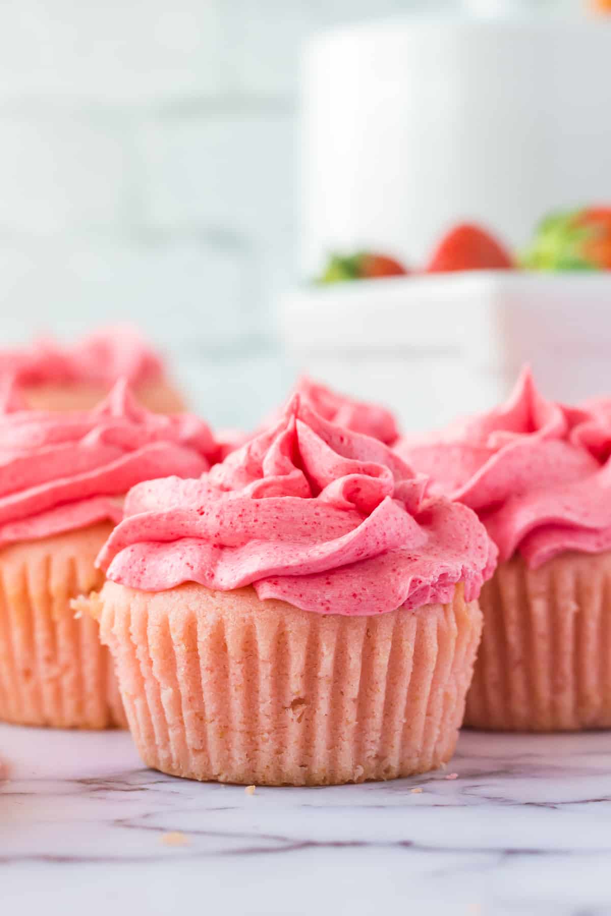 Pink strawberry cupcakes with frosting.