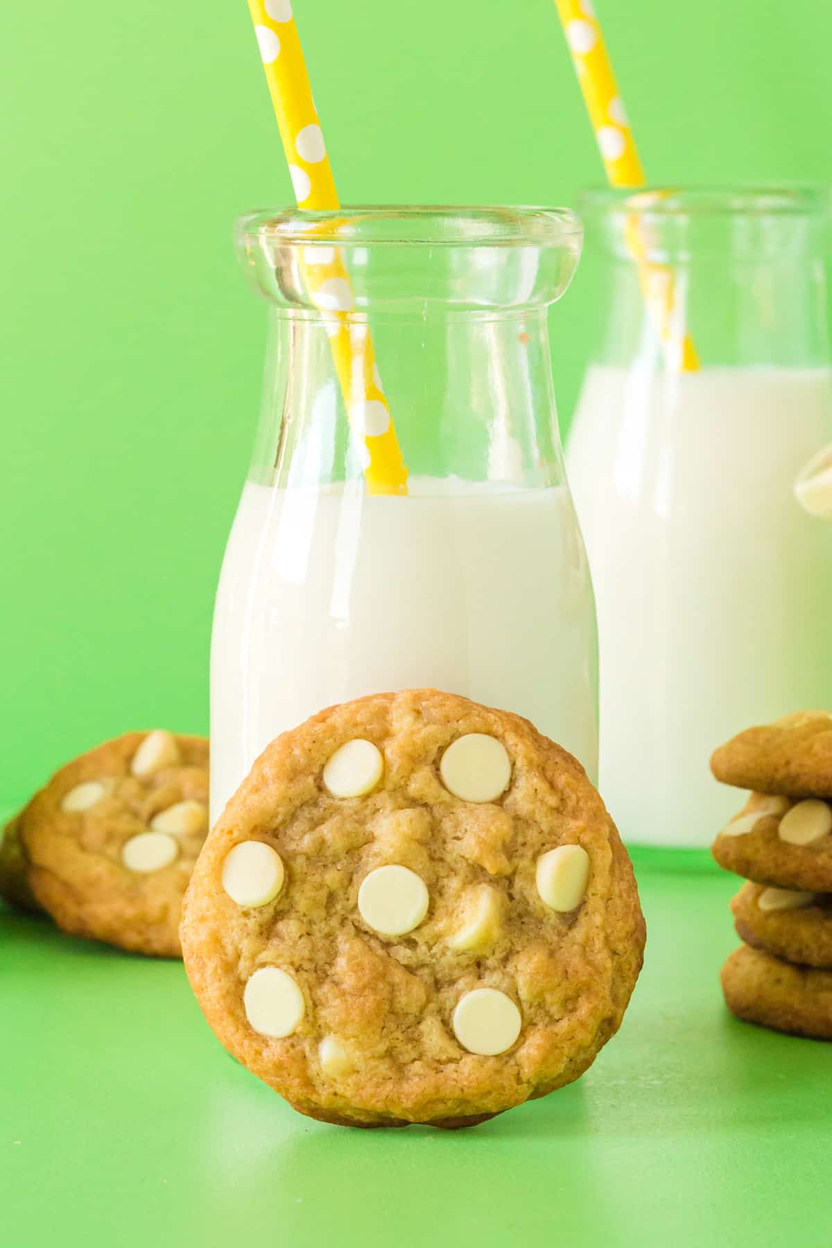 Banana Pudding Cookie with white chocolate chips leaning against a glass of milk.