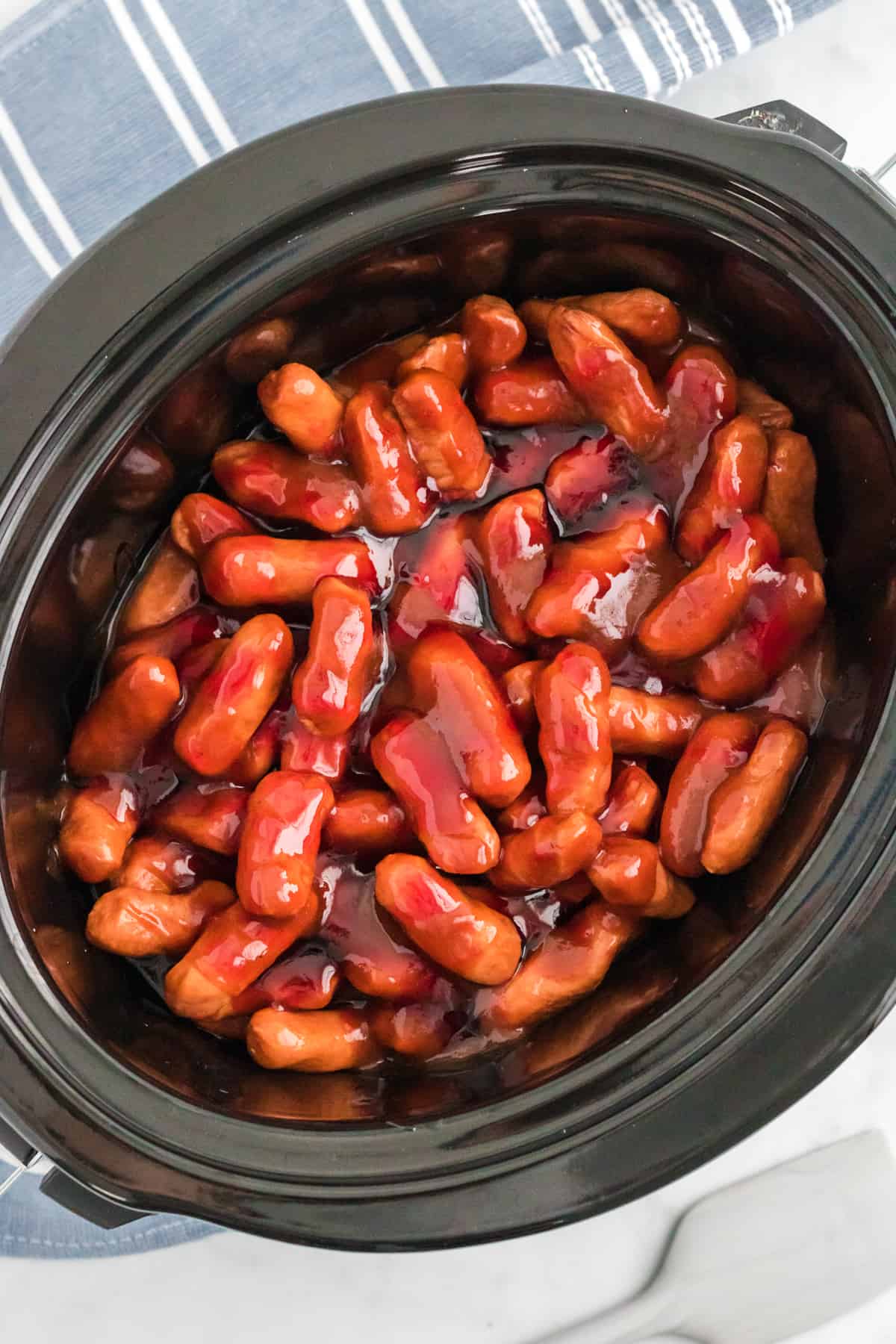 Lil smokies cocktail weiners in crocpot covered in bbq sauce and grape jelly.