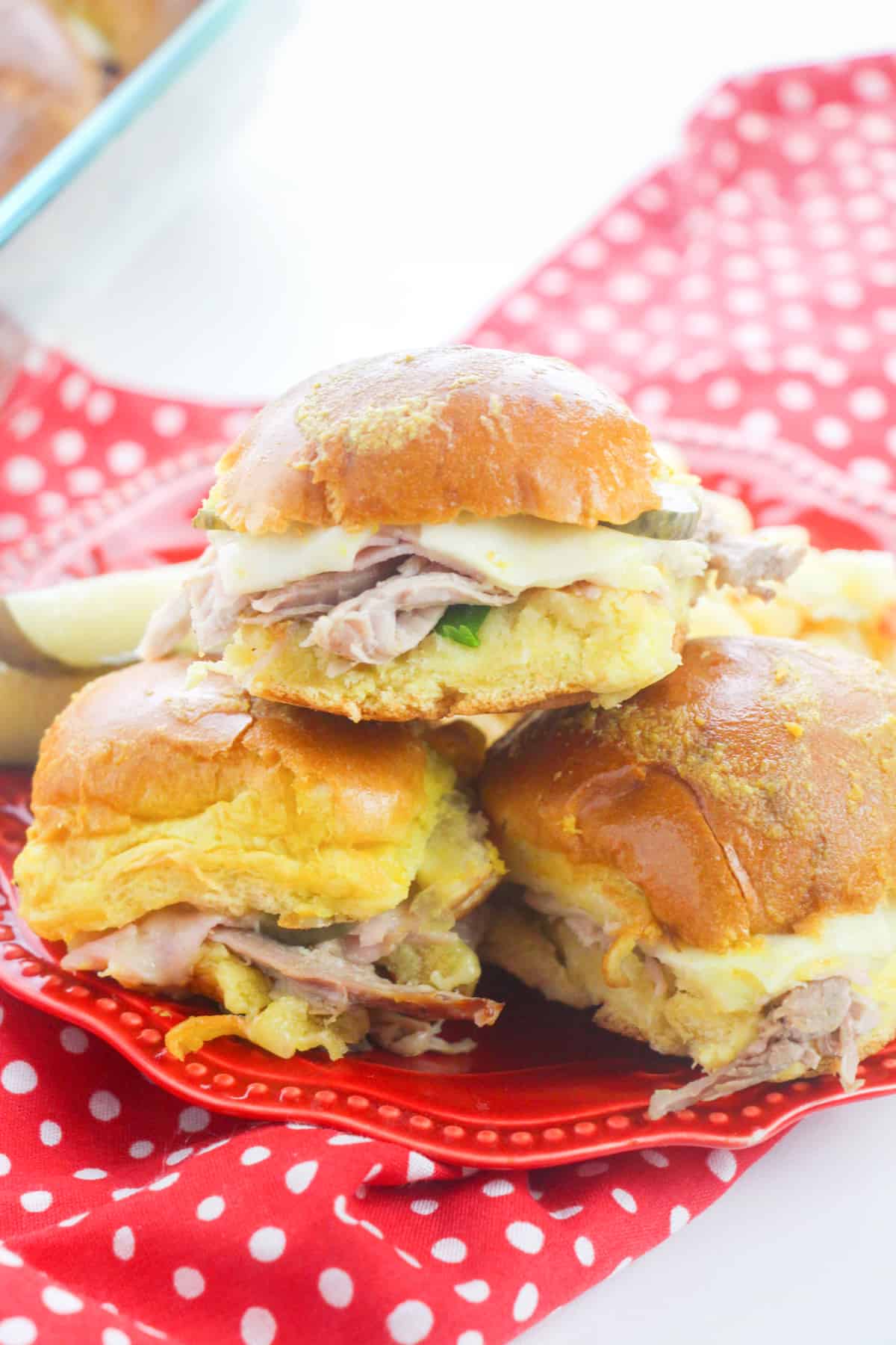 Cuban Slider sandwiches with pork, ham, swiss, pickles, and mustard on hawaiian rolls.