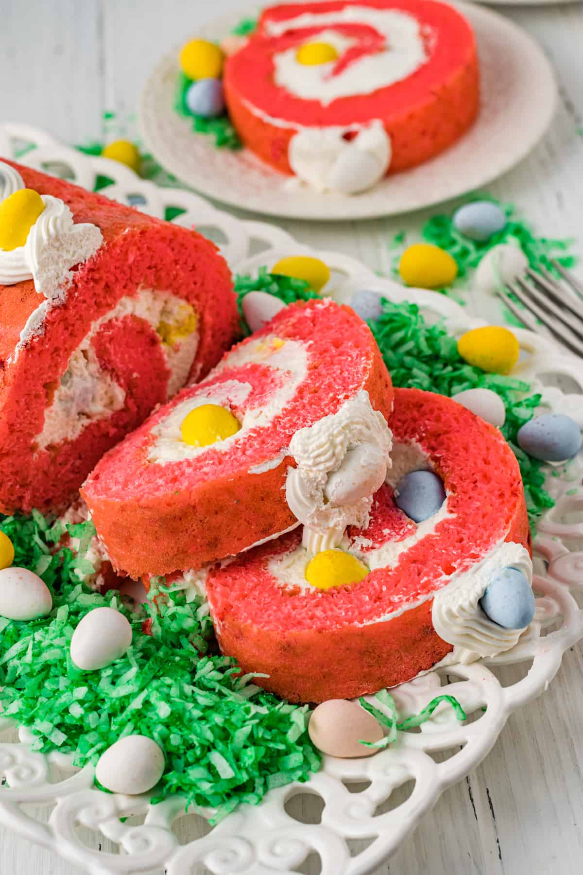 Sliced Easter Cake Roll with green shredded coconut and mini eggs.