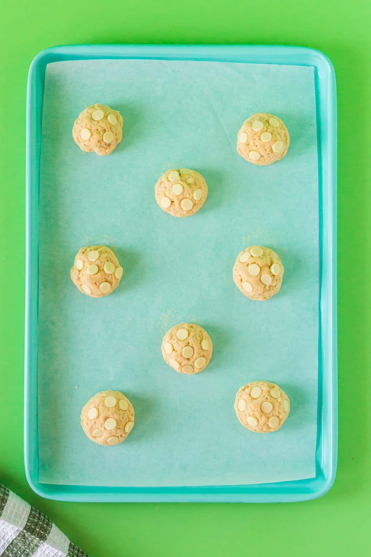 White chocolate chip banana cookies on lined baking sheet.