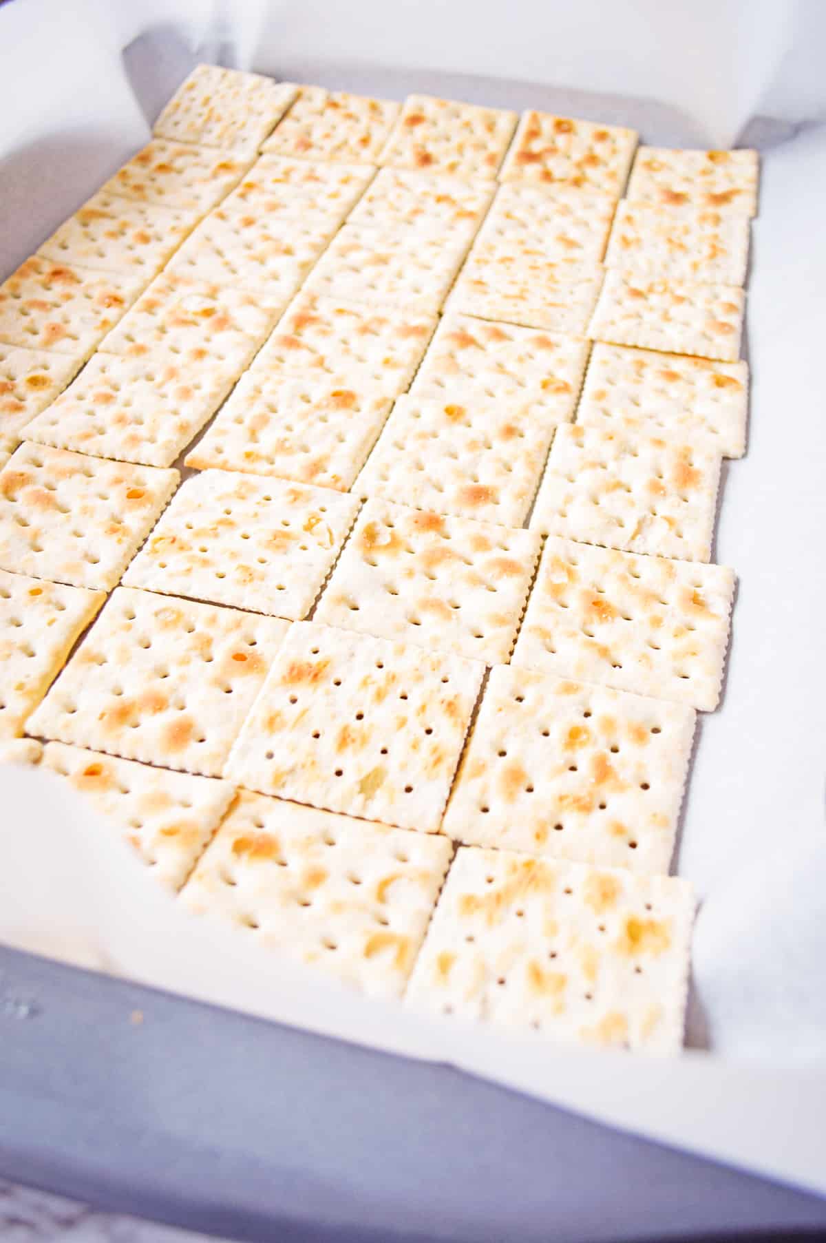 Saltine crackers on lined baking sheet