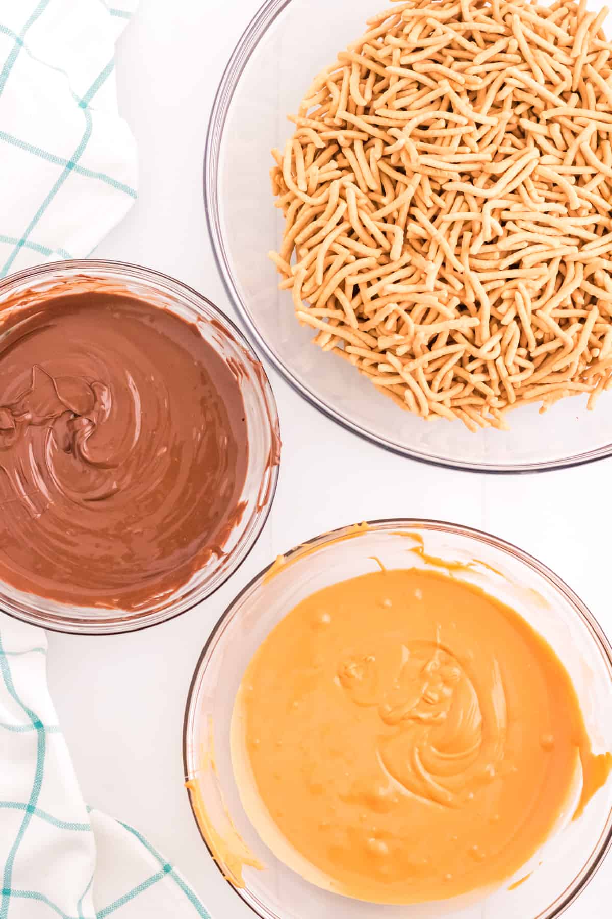 Bowl of melted chocolate, bowl of melted butterscotch, and bowl of chow mein noodles.