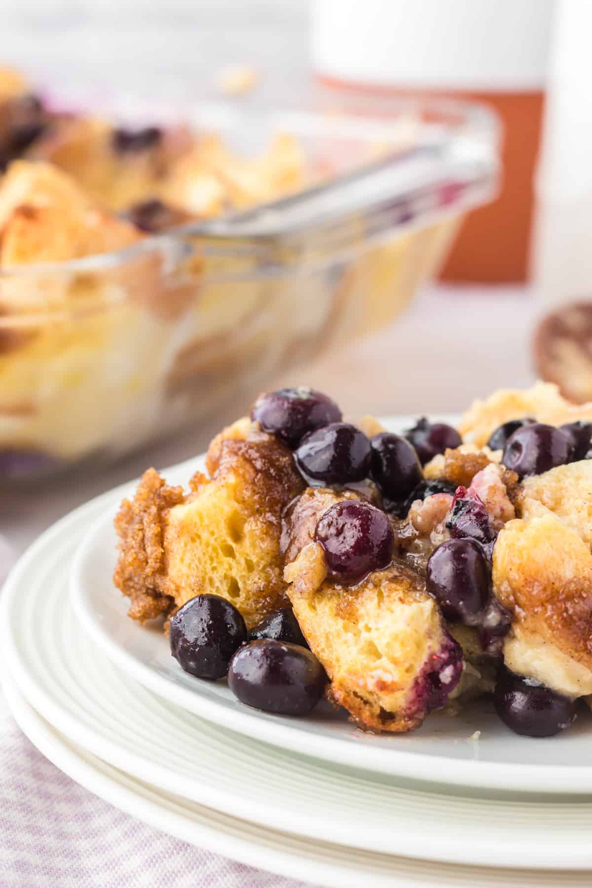 Blueberry french toast breakfast casserole on white plate.