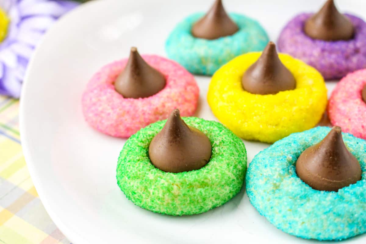 Sugar cookies rolled in colored sugar with chocolate kisses pressed in the center.