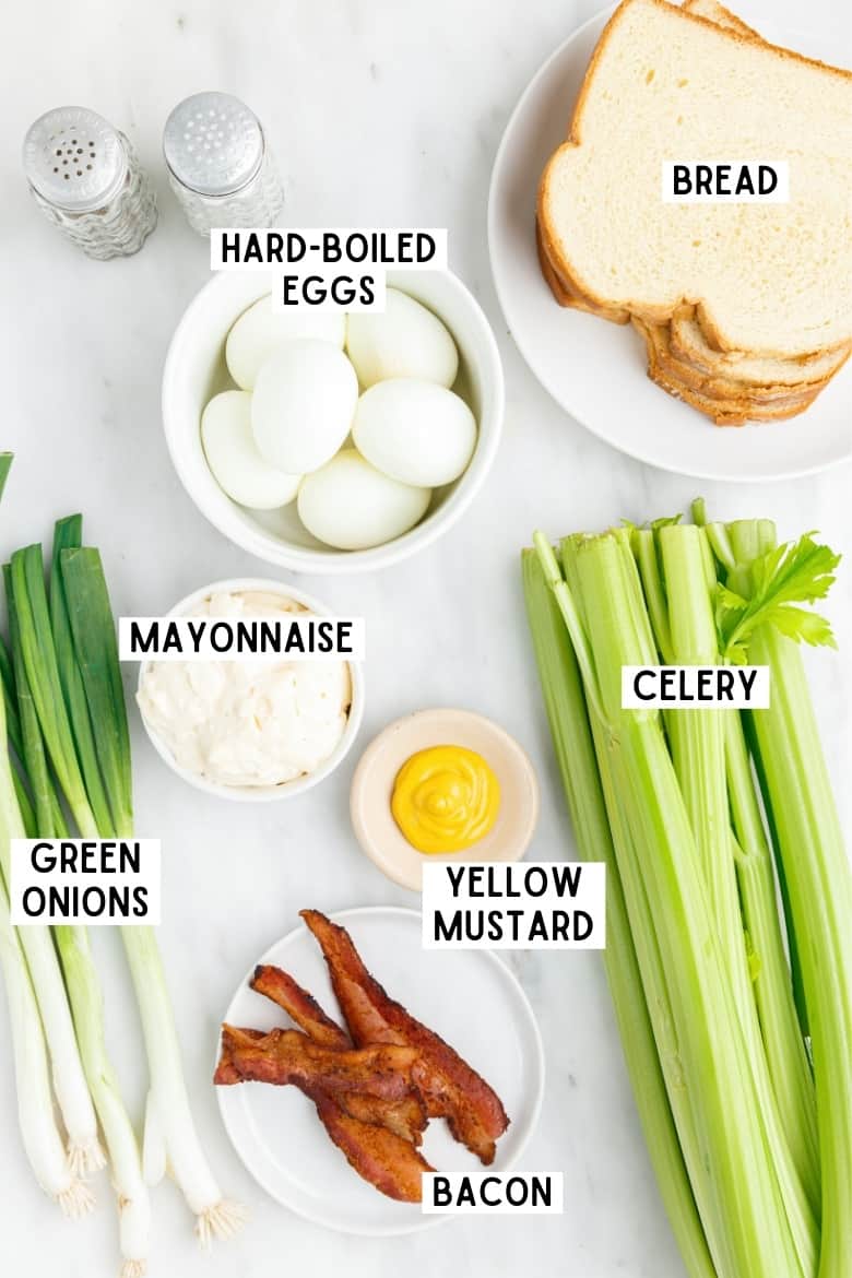 6 hard boiled eggs, slices of sandwhich bread, green onions, celery, yellow mustard, mayonnaise, cooked bacon, and salt and pepper shakers.