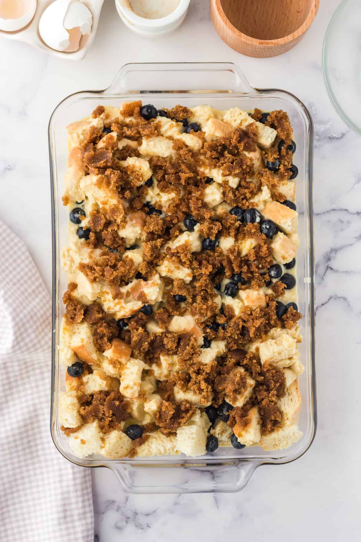Unbaked french toast casserole with blueberries and cinnamon sugar topping.