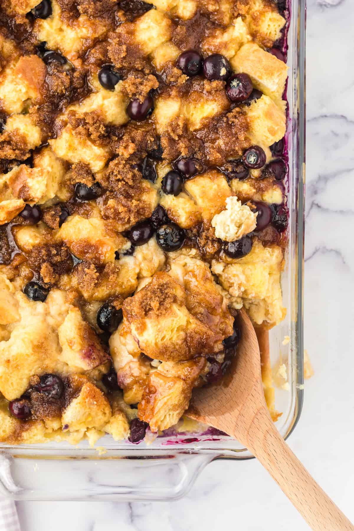 Blueberry French Toast Casserole with spoon scooping out a serving.