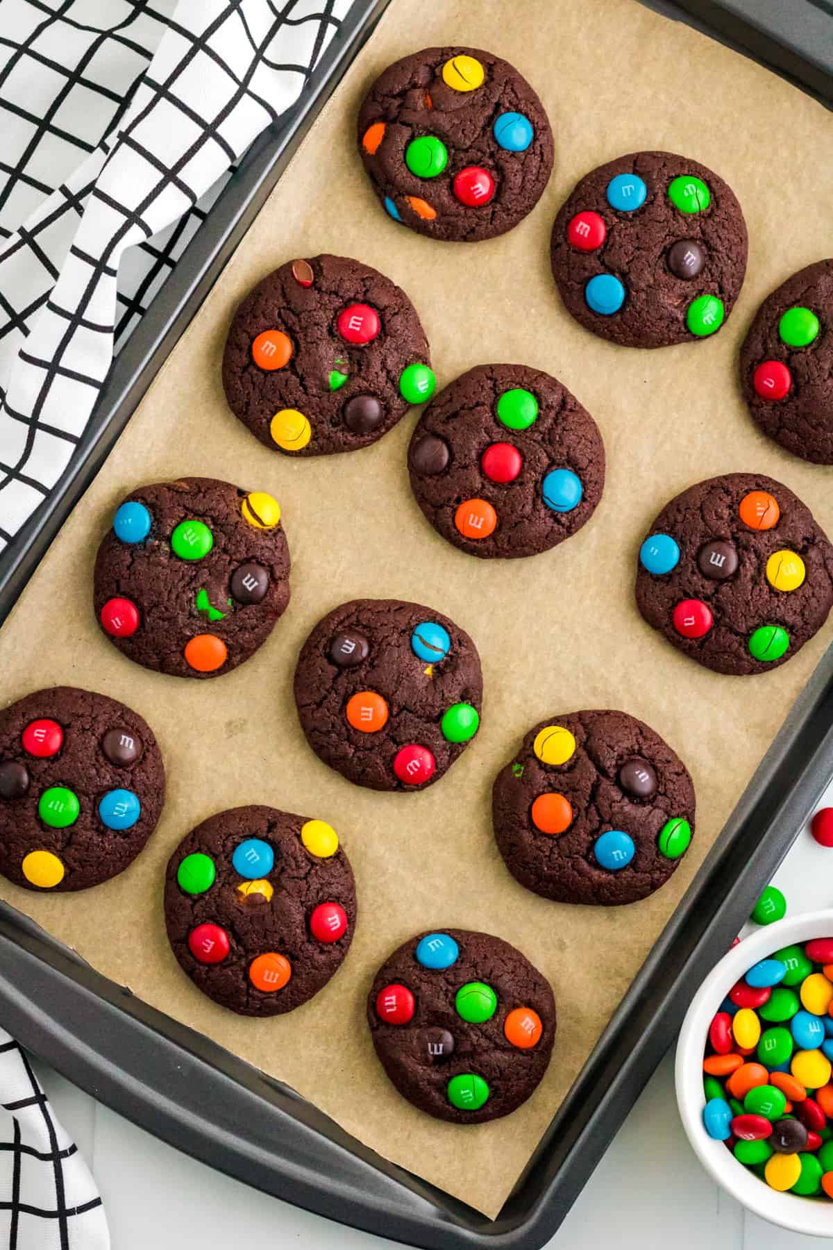 Chocolate M&M Cookies on lined baking sheet.