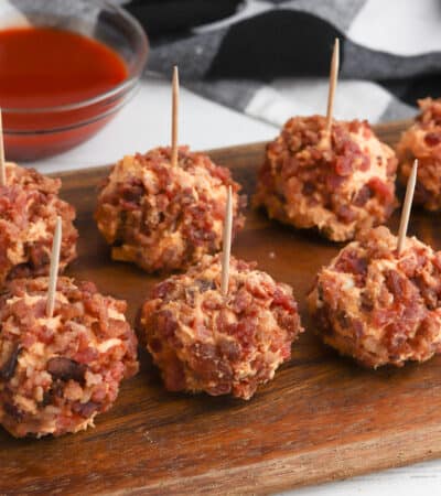 Buffalo chicken cheese balls with bacon on the outside and tooth picks sticking out on top.
