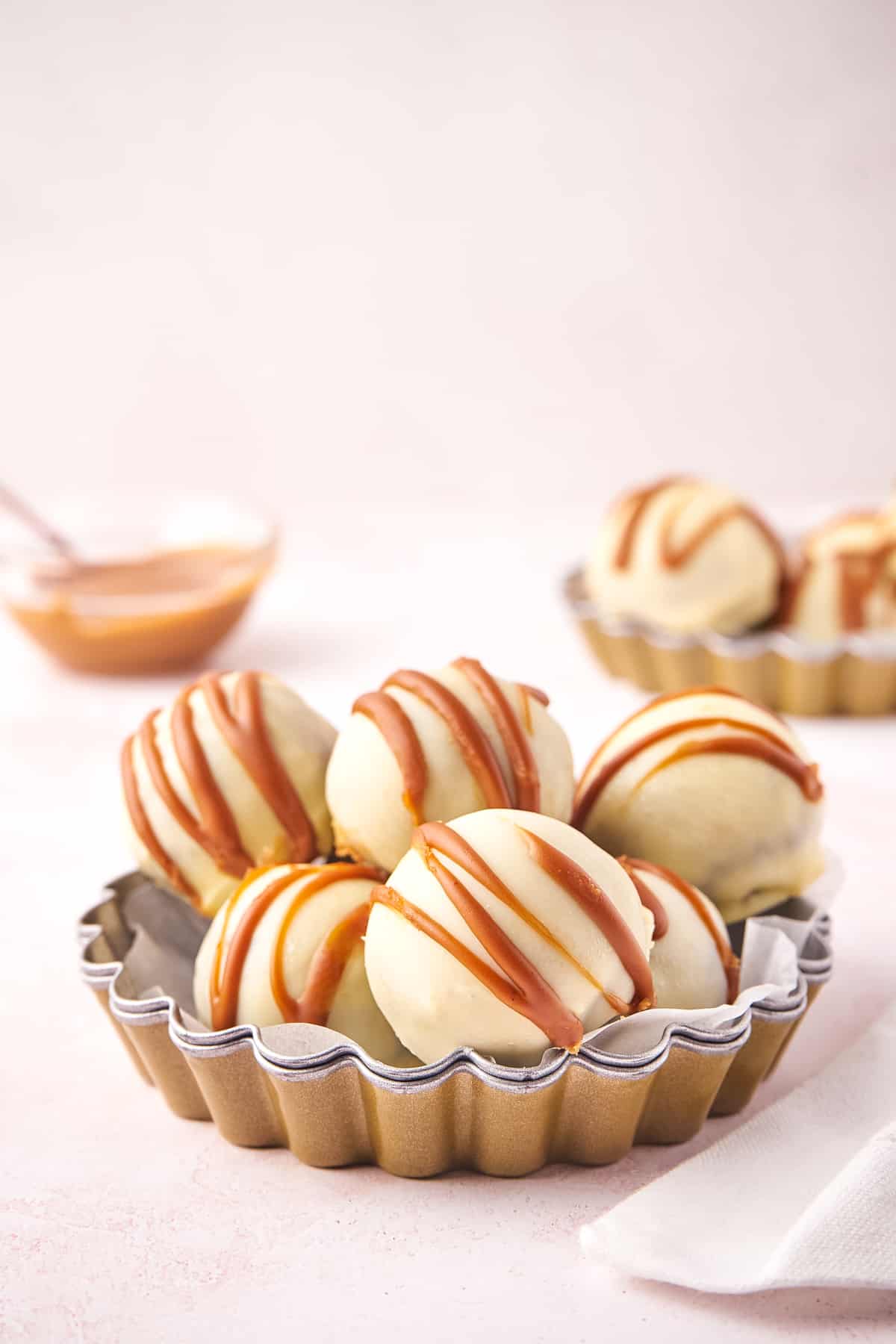 No-bake Biscoff cookie truffles with white chocolate coating and cookie butter drizzle.