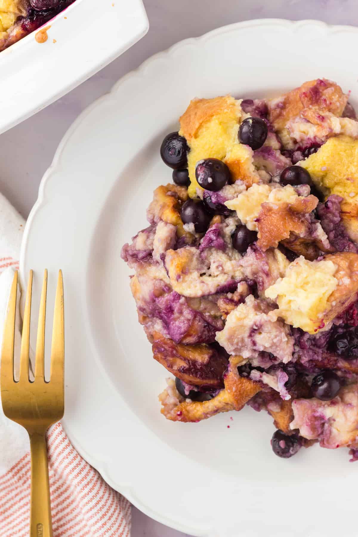 Blueberry lemon bread pudding scooped onto a plate.