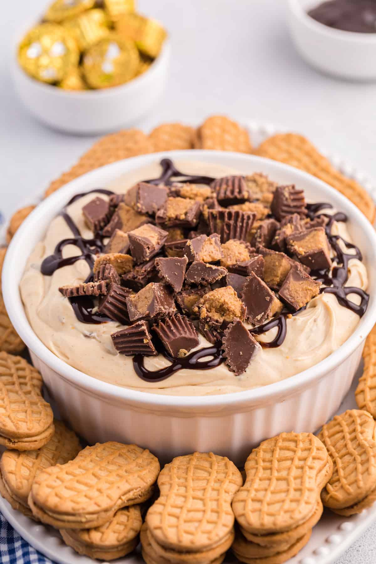 Reese's Peanut Butter Cup Dip in white serving bowl served on a platter with Nutter Butter Cookies for dipping.