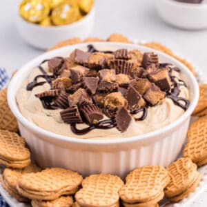 Reese's Peanut Butter Cup Dip in white serving bowl served on a platter with Nutter Butter Cookies for dipping.
