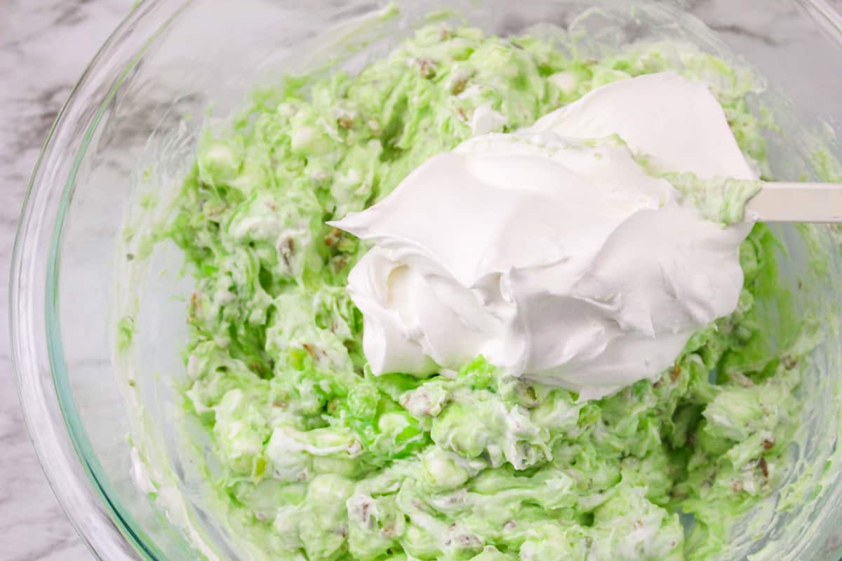 Pistachio salad mixture with cool whip on top.