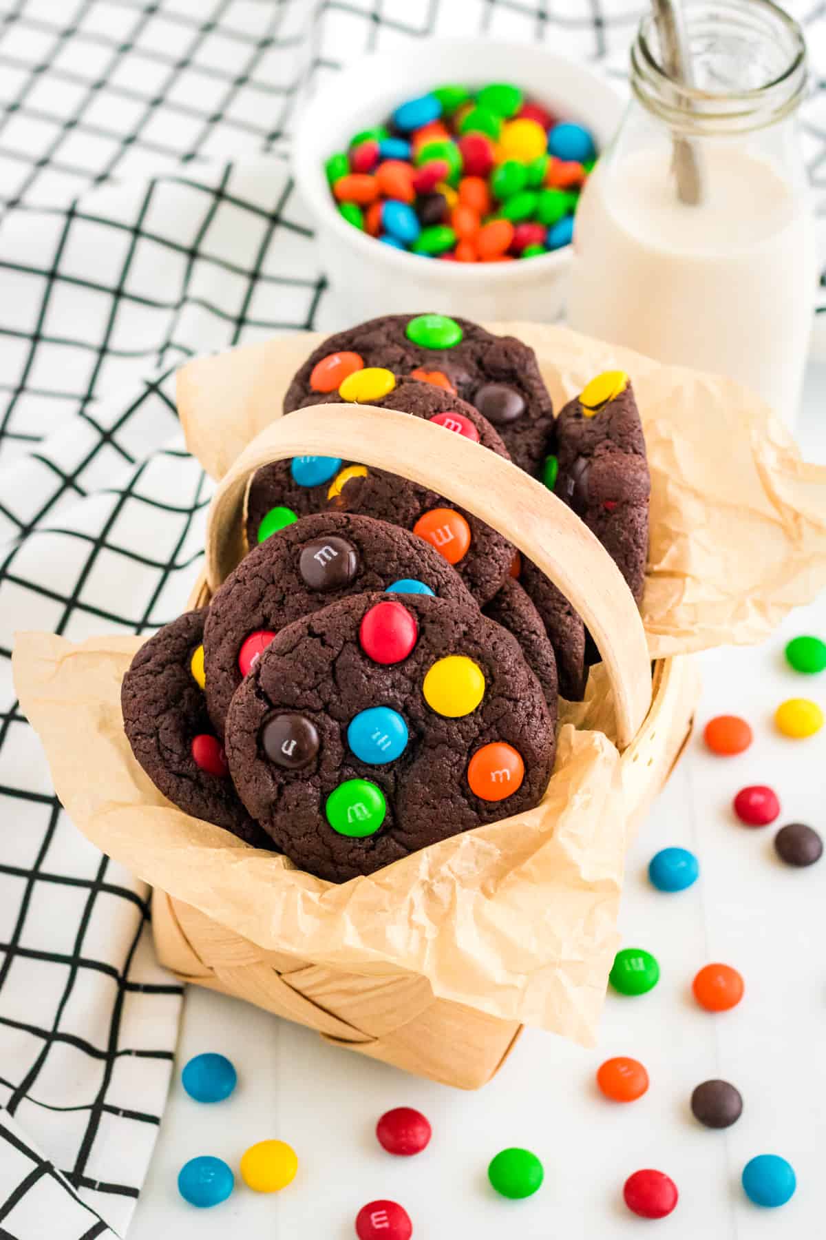 Chocolate M&M cookies in parchment lined basket.