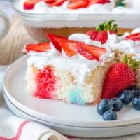 Red, white, blue 4th of july poke cake with fresh berries.