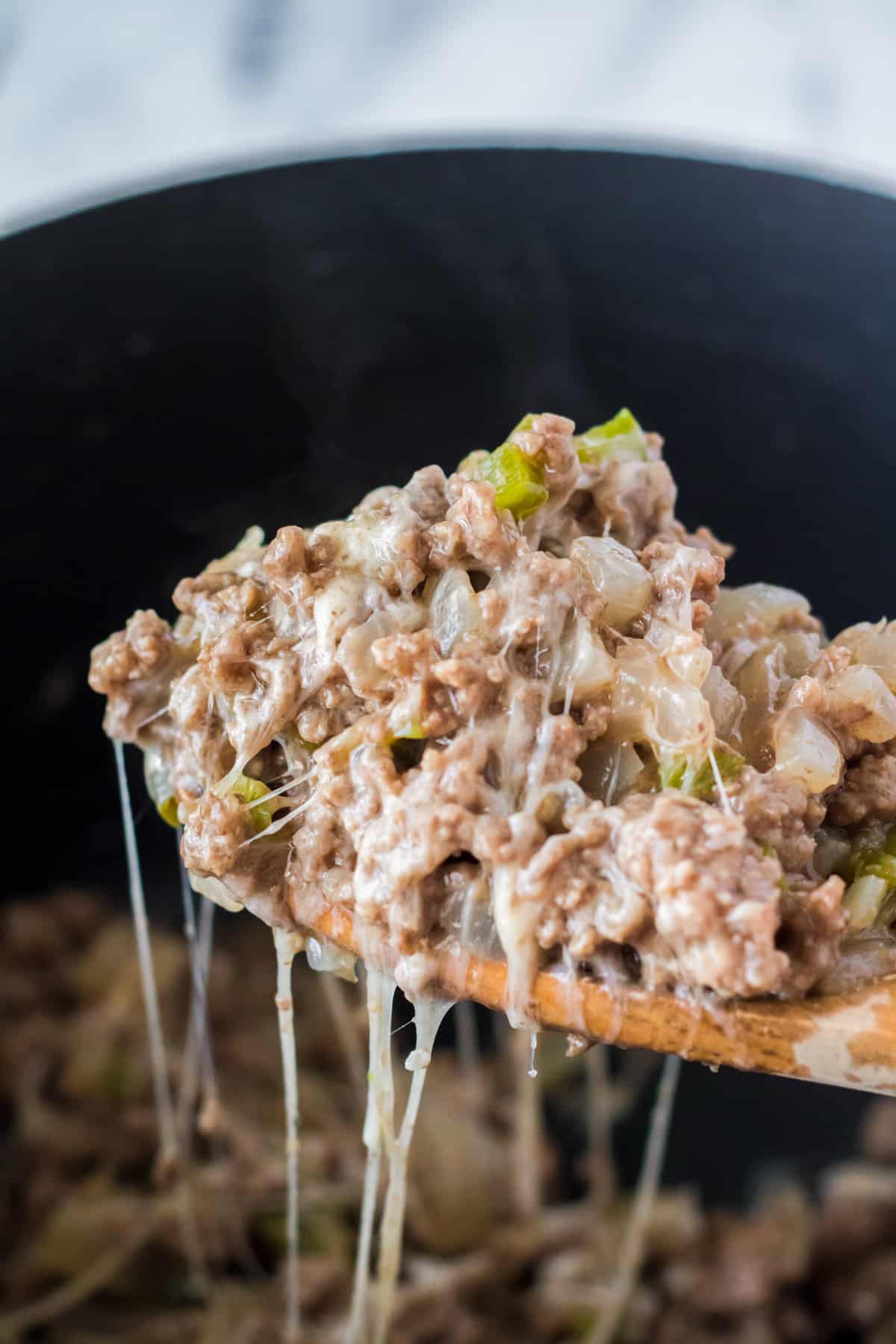 Spoonful of cheesy sloppy joes in slow cooker.