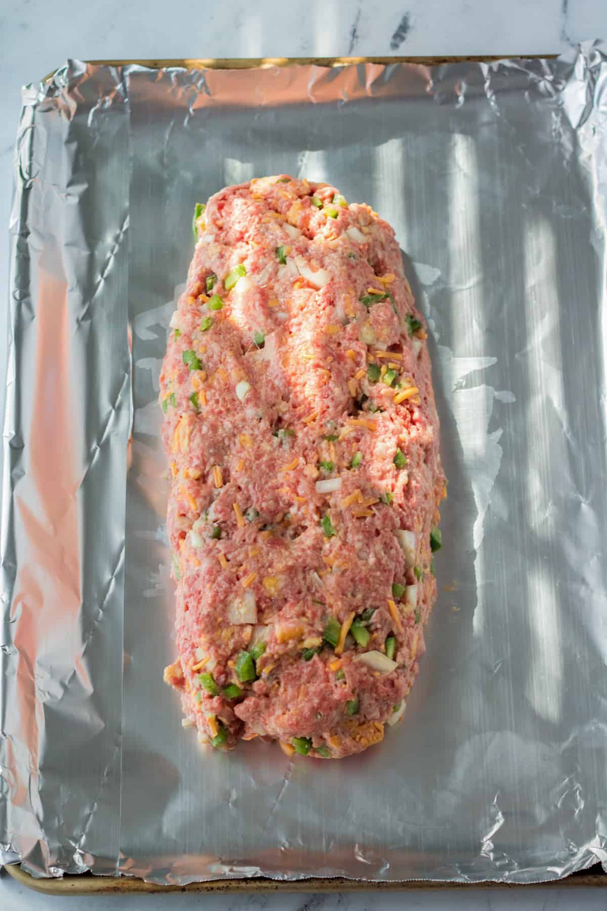 Copycat cracker barrel meatloaf formed into loaf-shape on foil lined pan.