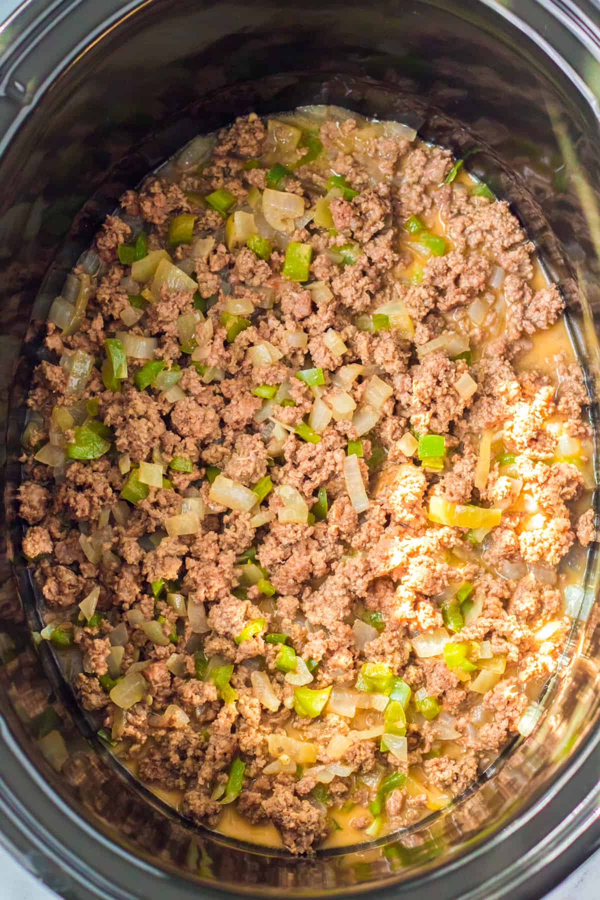 Ground beef with onions and peppers in slow cooker.