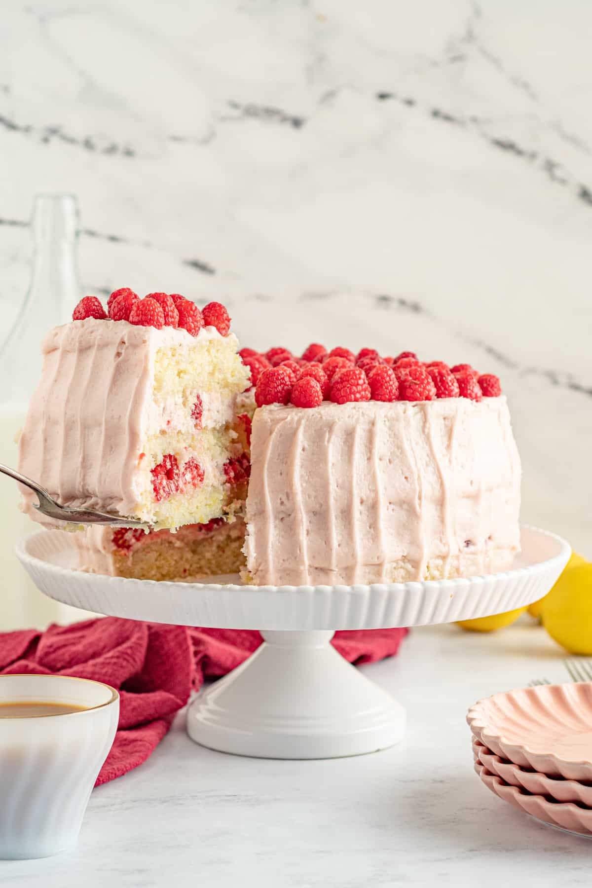 Slice of cake being lifted from the lemon and raspberry layer cake.