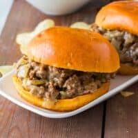 Slow cooker Philly Cheesesteak Sloppy Joes on buns with potato chips.