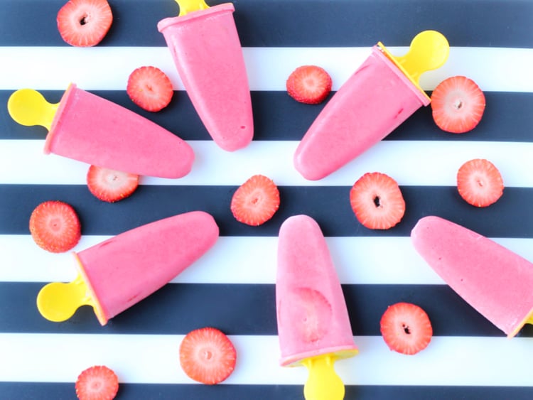 Strawberries and cream popsicles with slices of fresh strawberries.