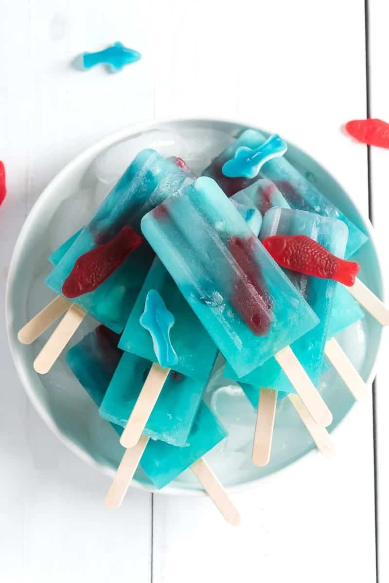 Blue ice pops with red swedish fish and gummy shakes inside.