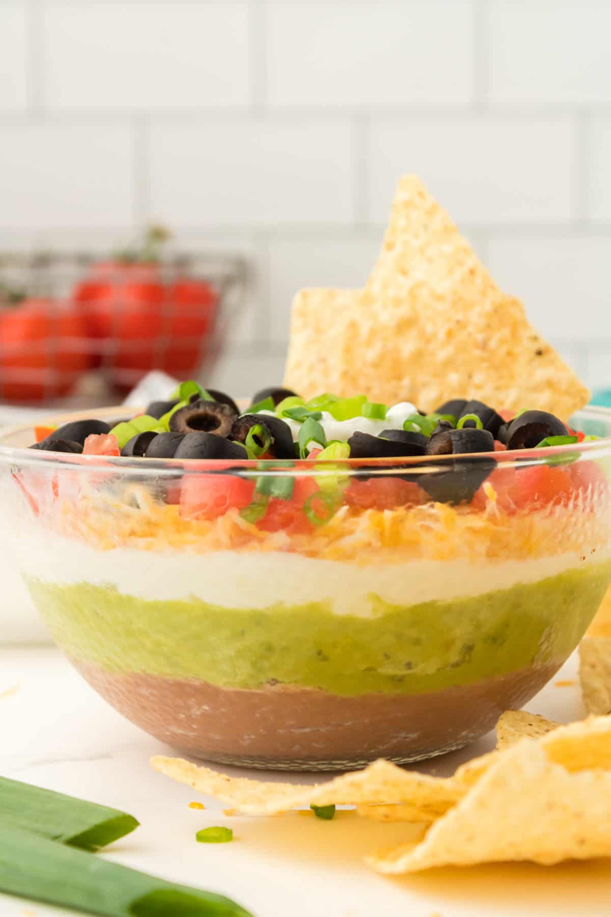 Side view of the bowl of 7 layer dip showing each of the ingredient layers.