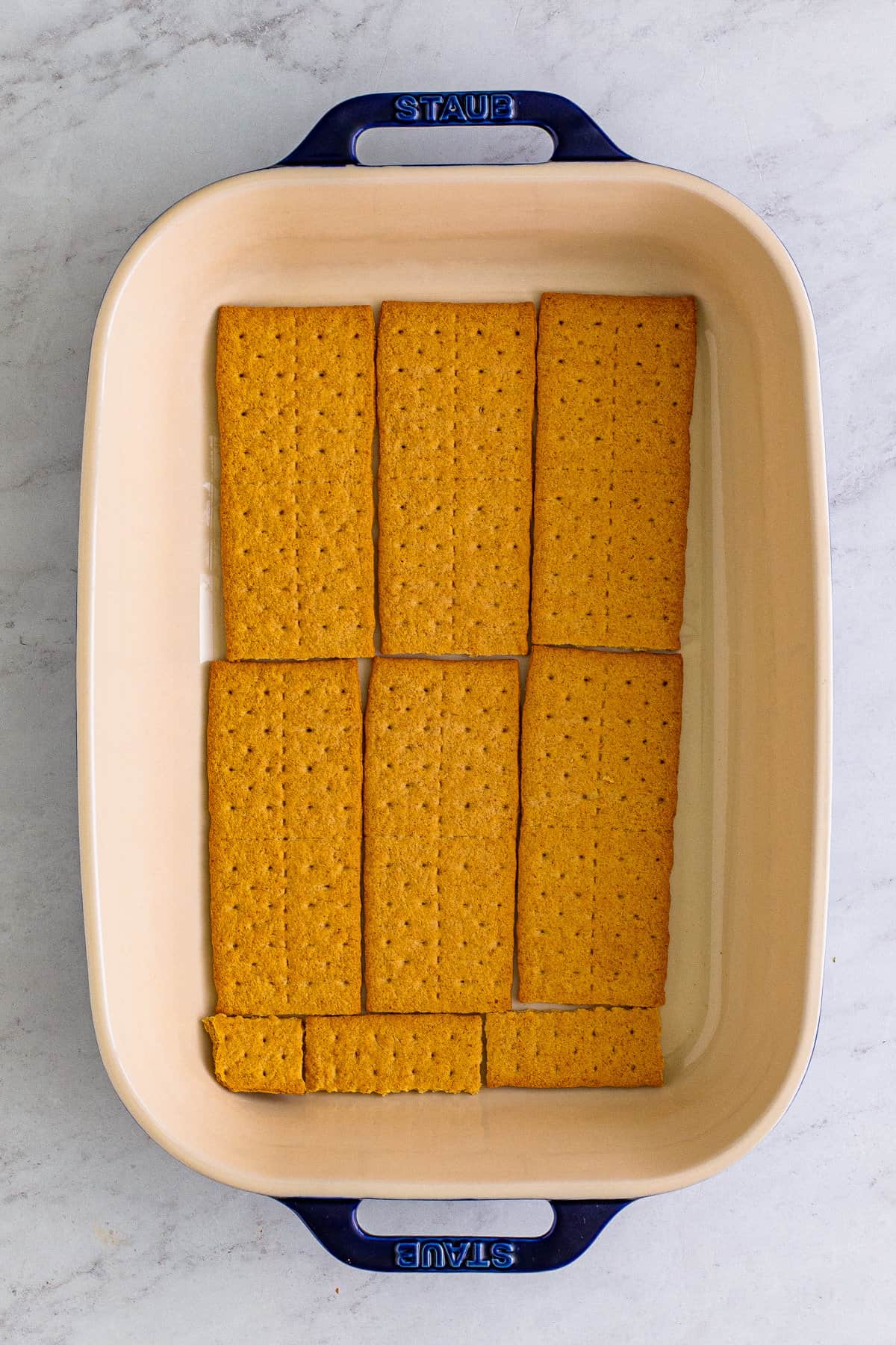 Whole graham crackers laid in an even layer in bottom of 9 x 13 baking pan.