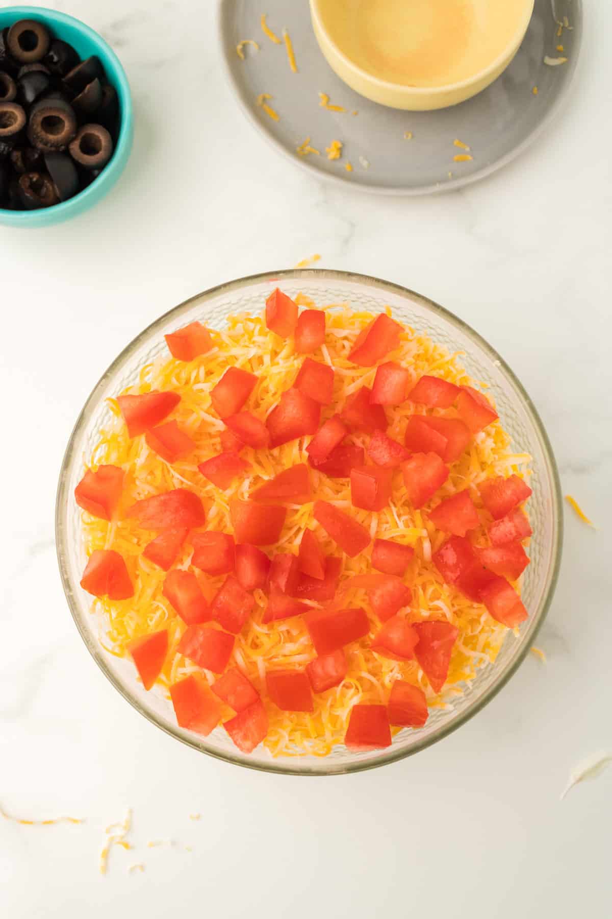 Shredded cheese and diced tomatoes addd to bowl.