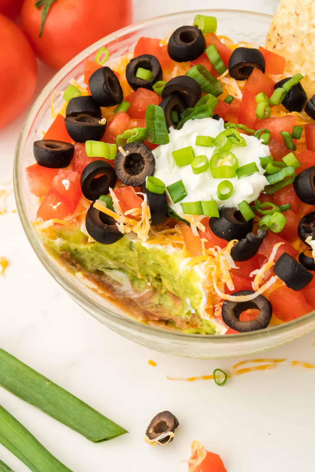Bowl of 7 layer taco dip with some eaten.