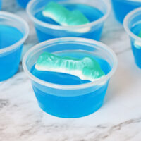 Shark jello shot with blue gelatin and shark gummy candy on top.