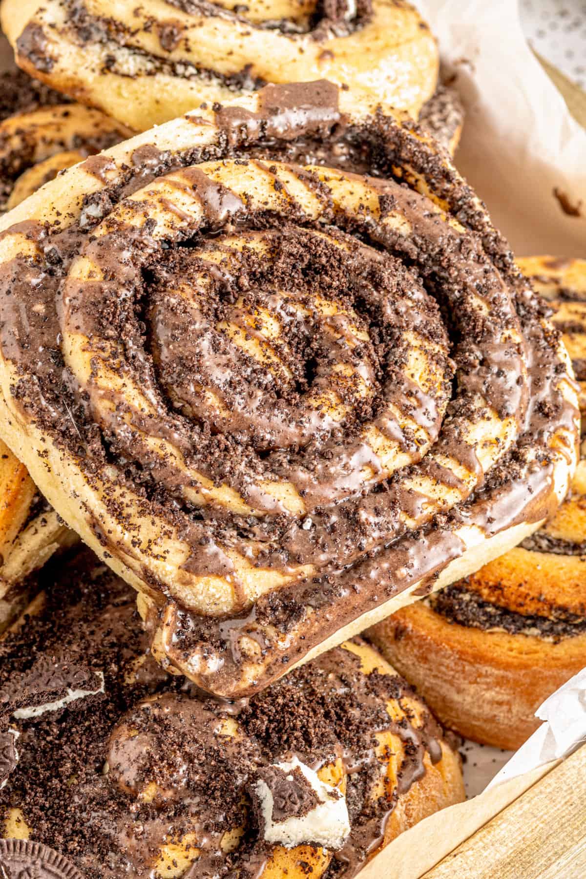 Cookies and cream cinnamon roll topped with glaze and crushed oreo cookies.
