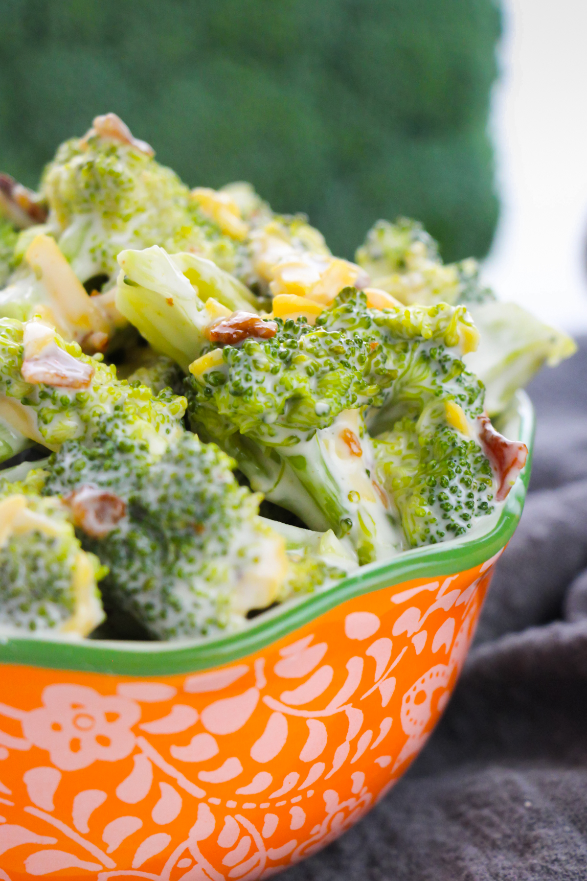 Close up side view of broccoli bacon cheddar salad in serving bowl.