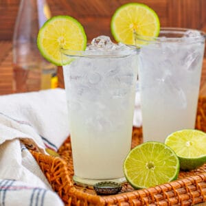 Ranch water cocktails on straw tray with lime garnish.