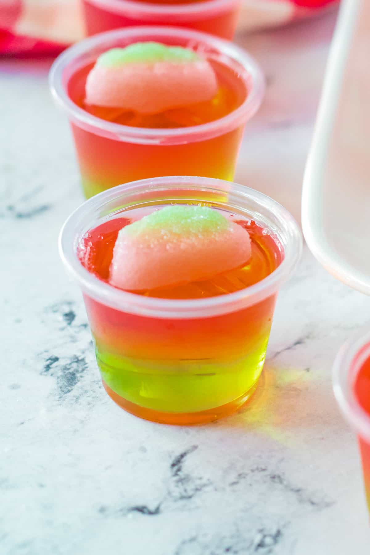 Pink and green jello shot topped with watermelon candy.