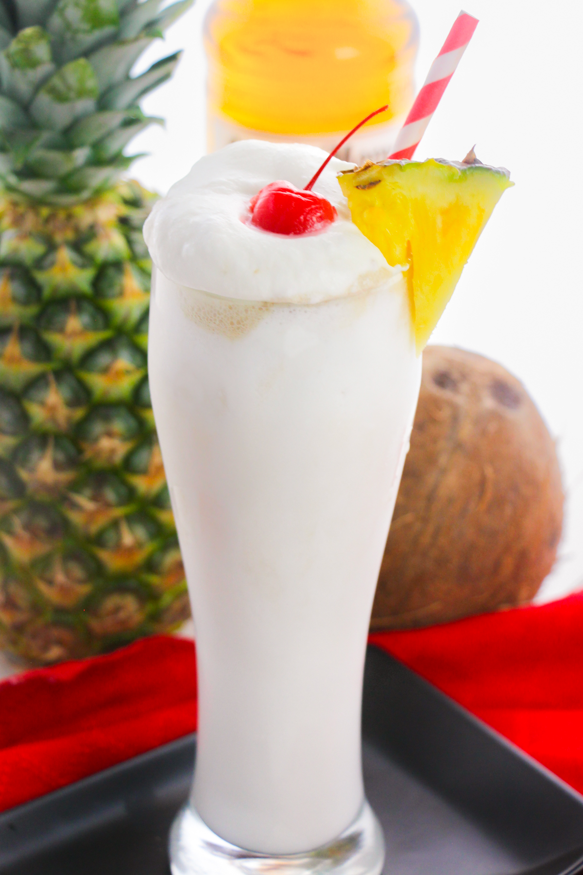 Creamy frozen pina colada with whipped cream, pineapple, and cherry.