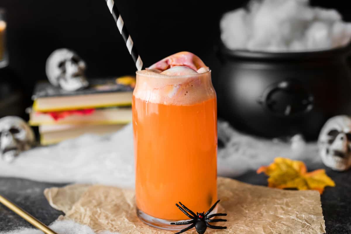 Orange hocus pocus Halloween punch for kids surrounded by Halloween decor.