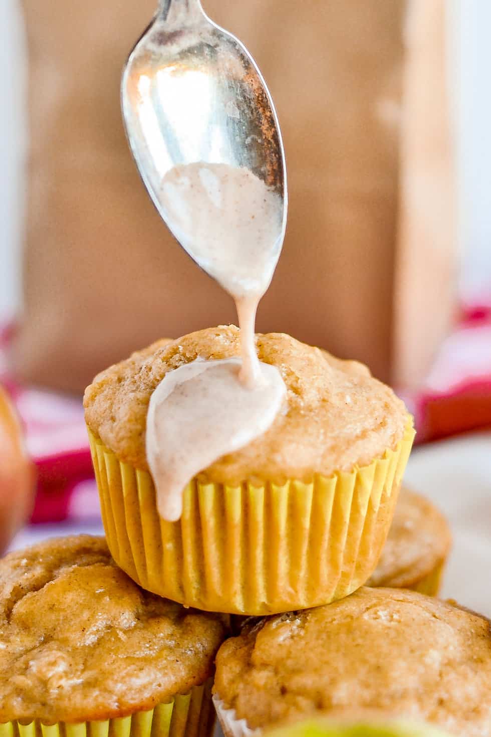 Apple Muffin with cinnamon glaze being poured over it.