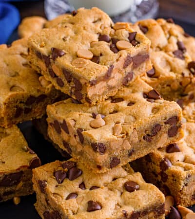 Peanut butter chocolate chip cookie bars piled on a plate.