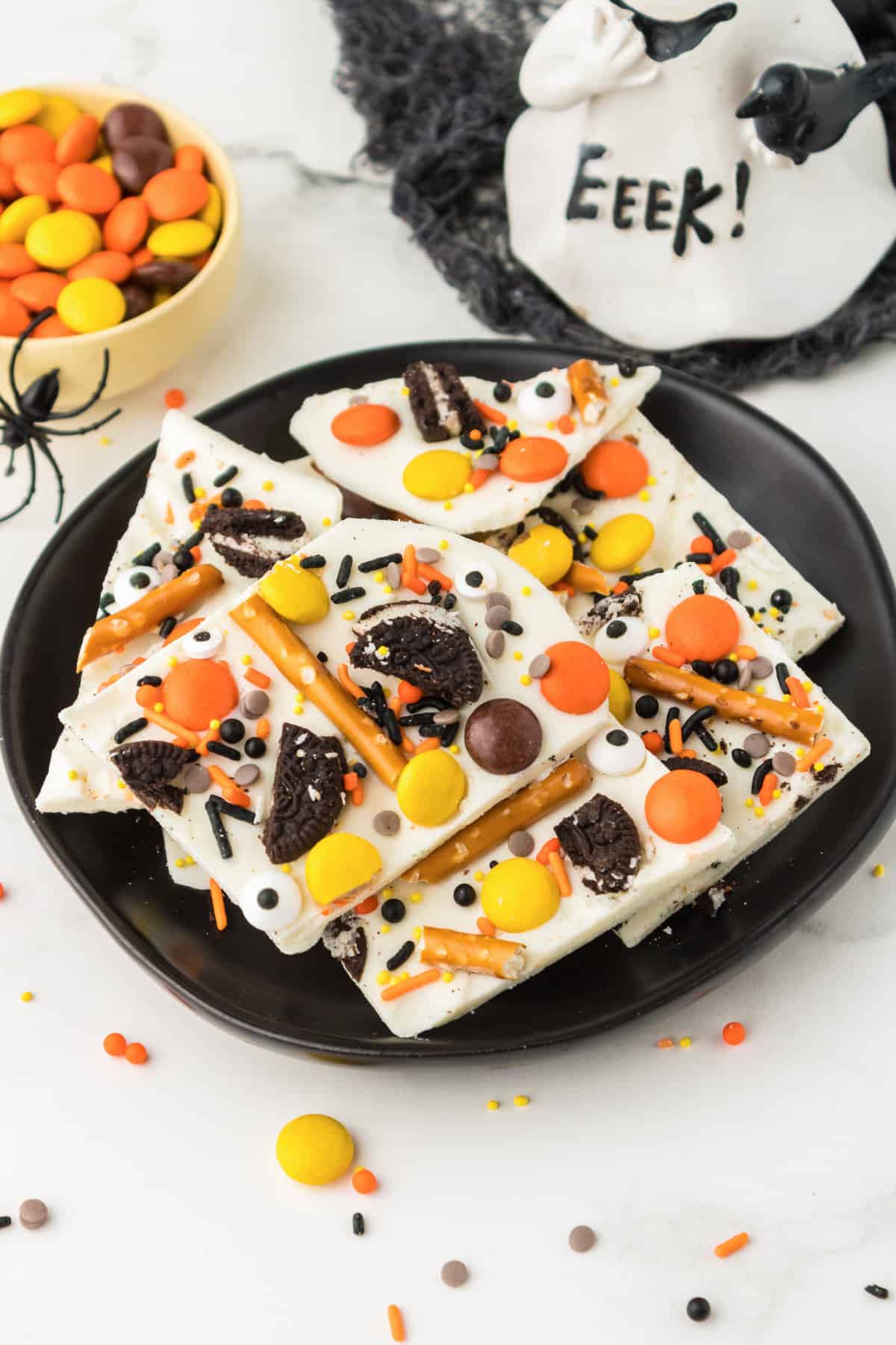 White chocolate Halloween Bark with pretzels, oreo cookies, and halloween candy.