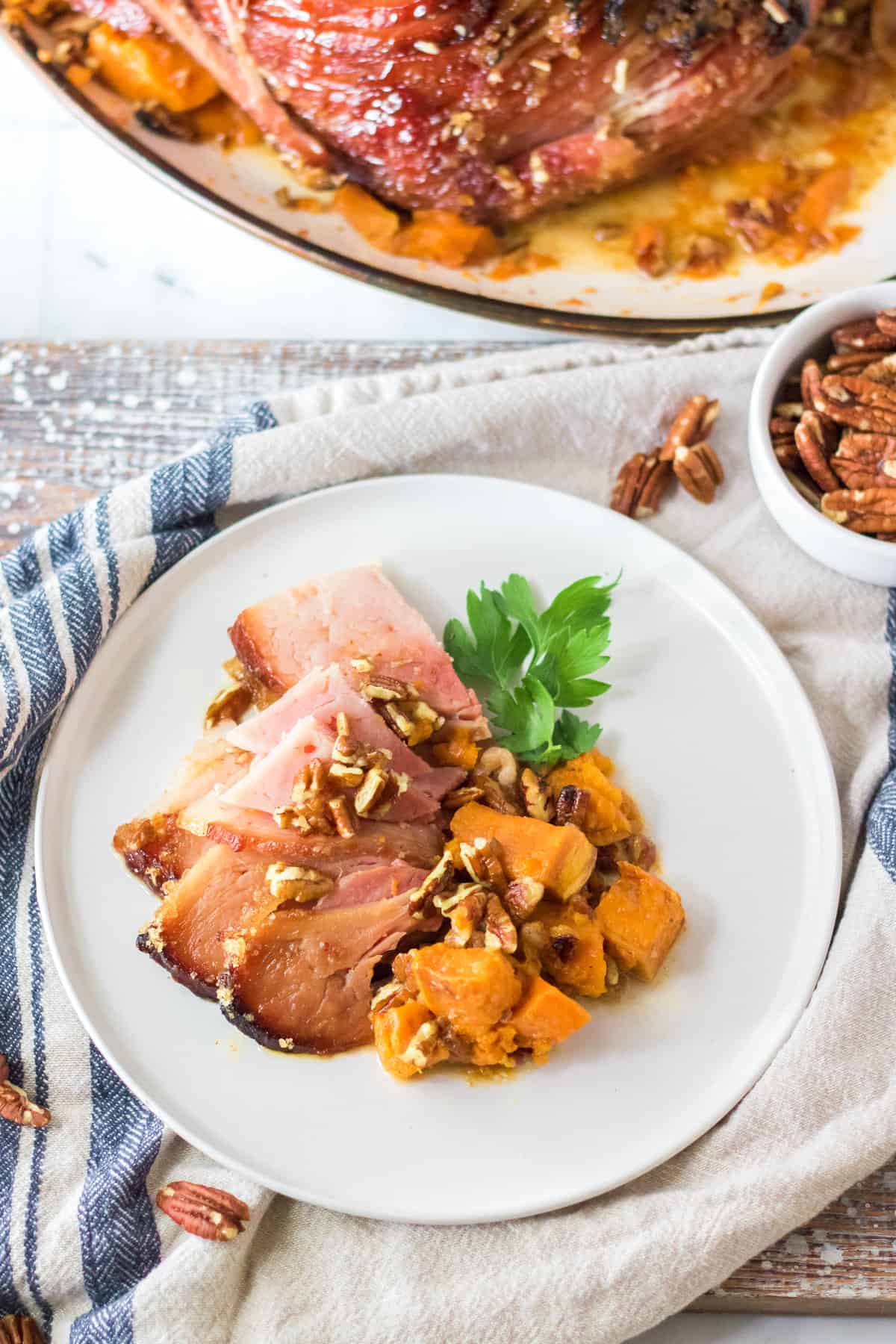 Sliced maple pecan ham served with sweet potatoes.