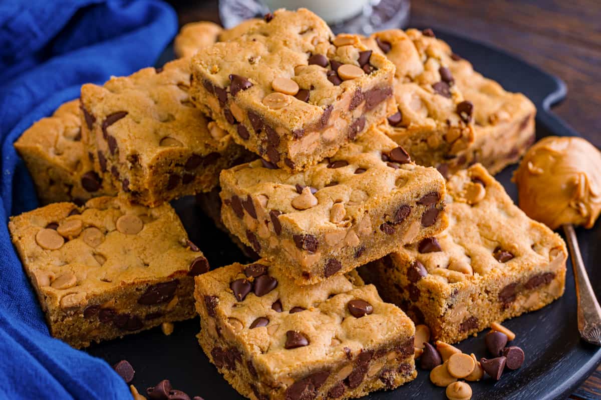 Peanut butter chocolate chip cookie bars piled on a plate.