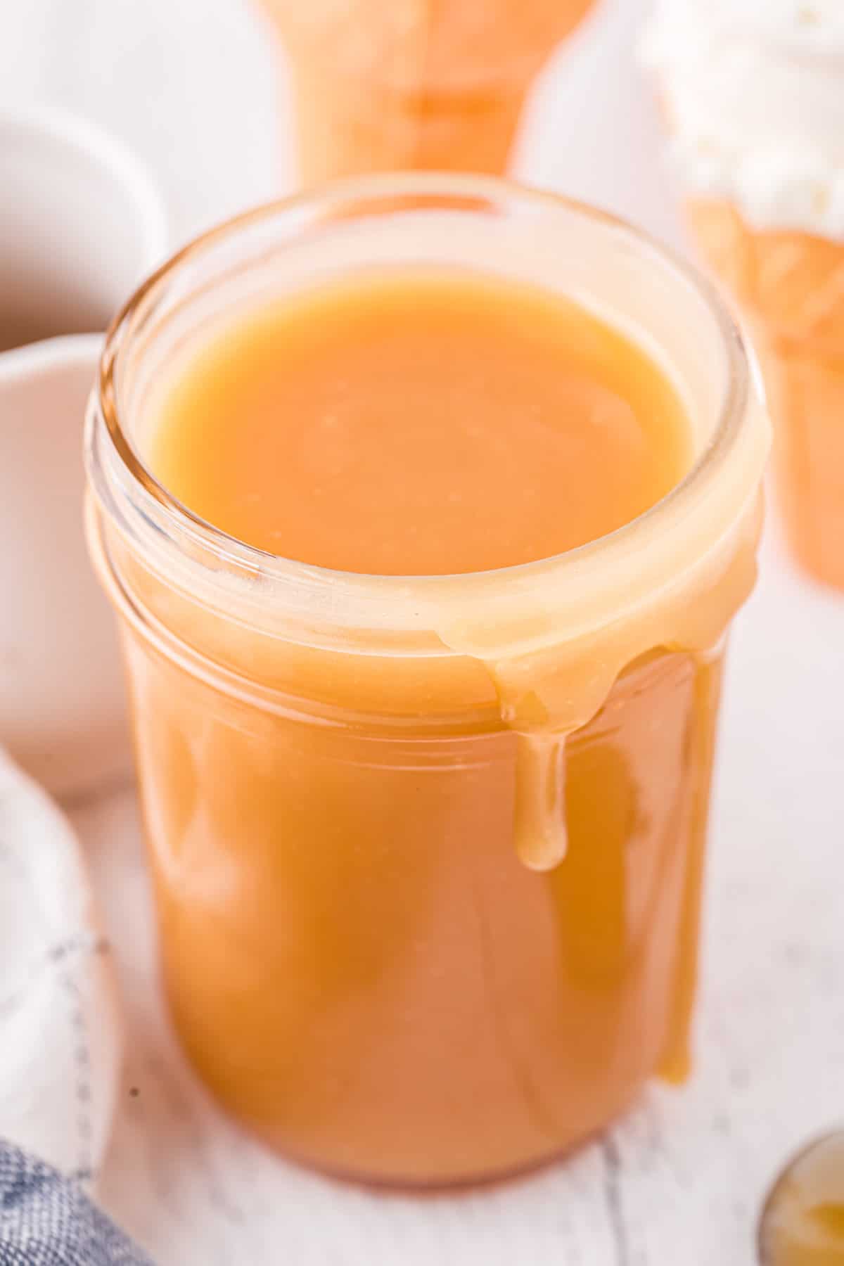 Homemade caramel sauce in glass mason jar.