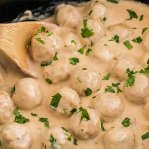 Slow Cooker Swedish Meatballs with creamy sauce and garnished with parsley.