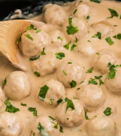Slow Cooker Swedish Meatballs with creamy sauce and garnished with parsley.