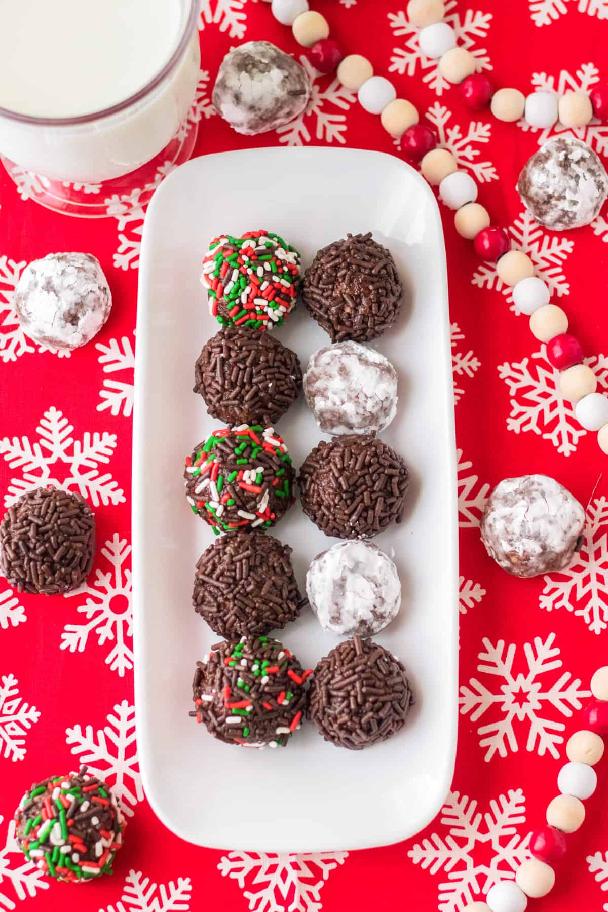 Tray of Christmas rum balls with glass of milk.